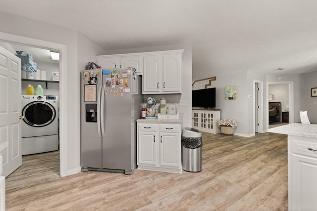 kitchen with white cabinetry, light hardwood / wood-style flooring, stainless steel fridge, and washer / dryer