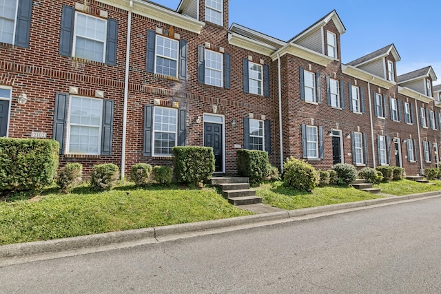 townhome / multi-family property featuring a front yard