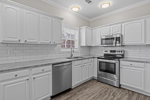 kitchen with visible vents, ornamental molding, dark wood-type flooring, stainless steel appliances, and a sink