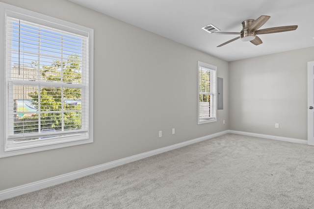 unfurnished room with carpet floors, a ceiling fan, visible vents, and baseboards