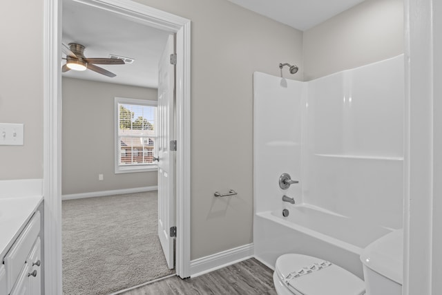 full bath with baseboards, a ceiling fan, toilet, tub / shower combination, and vanity