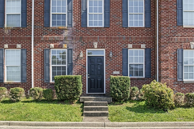 property entrance featuring brick siding