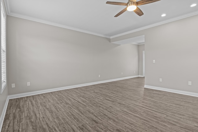 spare room featuring crown molding, dark wood-style flooring, and baseboards