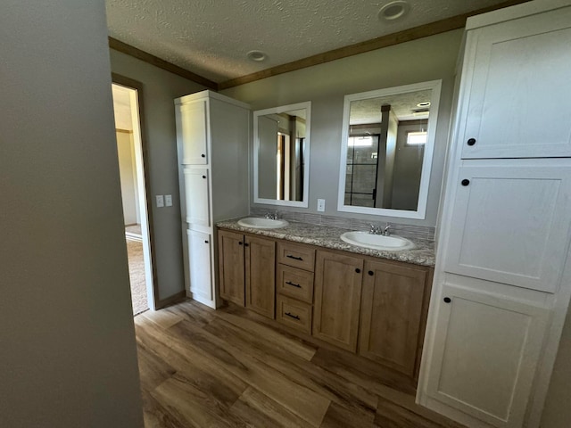 bathroom featuring vanity, hardwood / wood-style floors, and a textured ceiling