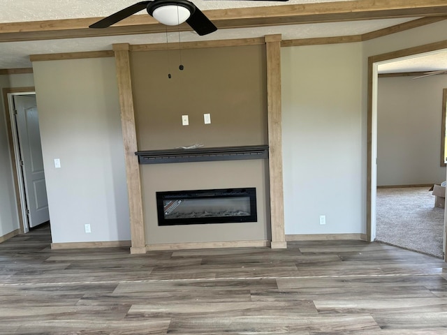 unfurnished living room featuring ceiling fan, beamed ceiling, and hardwood / wood-style flooring