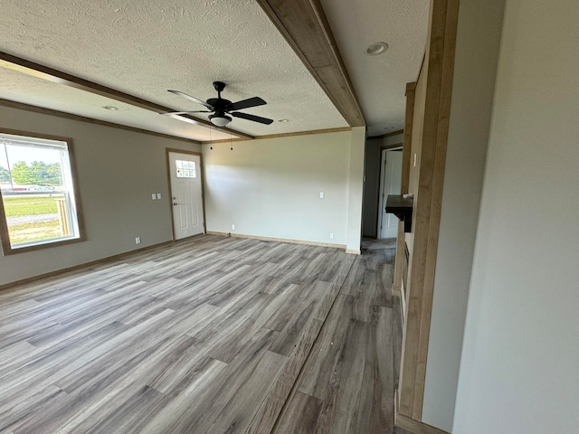 unfurnished living room with ceiling fan, light wood-type flooring, and a textured ceiling