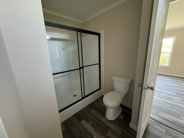 bathroom featuring crown molding, hardwood / wood-style floors, toilet, and walk in shower