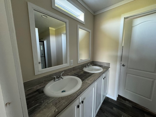 bathroom with crown molding, vanity, and hardwood / wood-style flooring