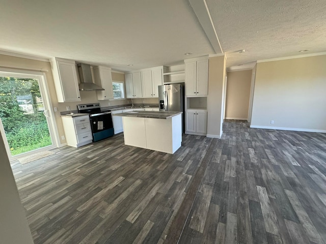 kitchen with appliances with stainless steel finishes, wall chimney exhaust hood, white cabinetry, and a healthy amount of sunlight