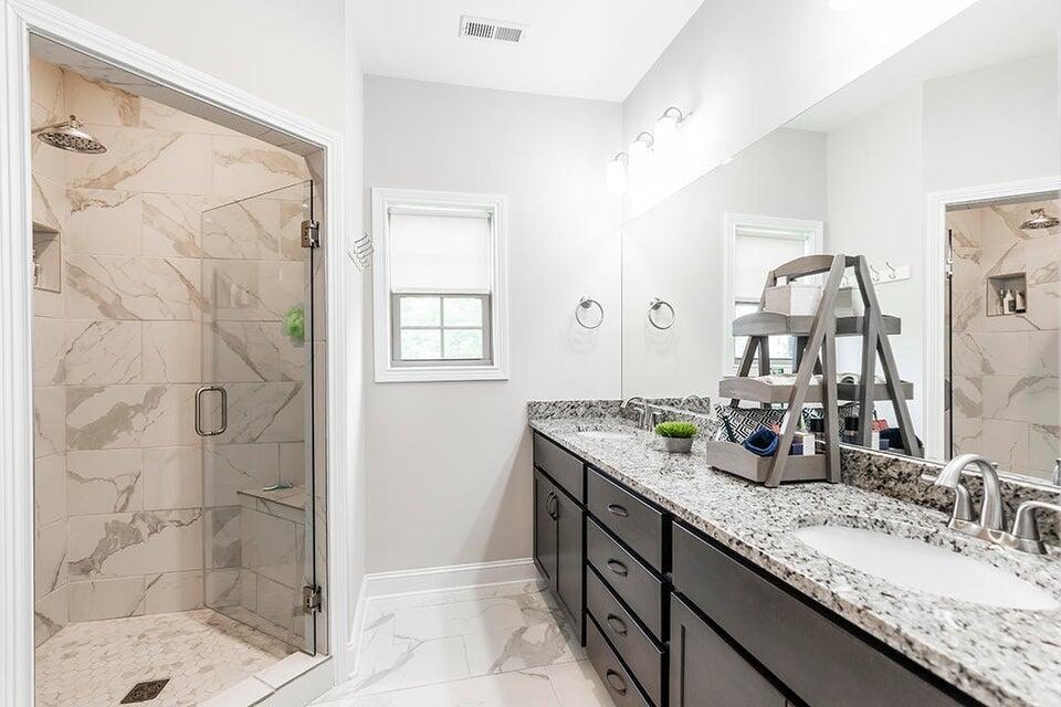 bathroom with a shower with door and vanity