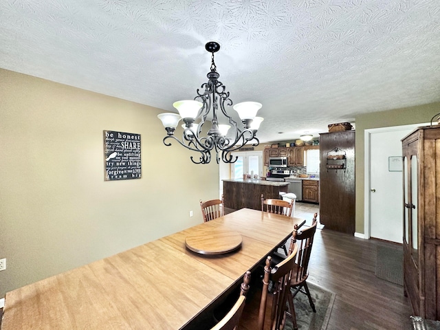 dining room with dark hardwood / wood-style floors, a chandelier, and a textured ceiling