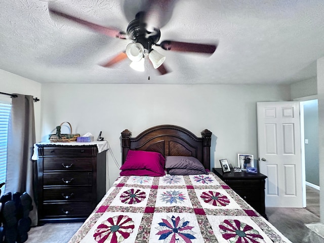 carpeted bedroom featuring a textured ceiling and ceiling fan