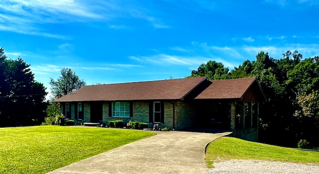 ranch-style home featuring a front lawn and a carport