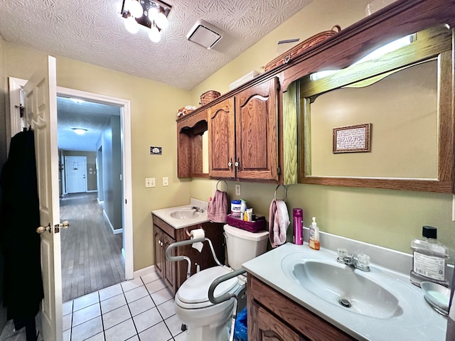 bathroom featuring vanity, toilet, wood-type flooring, and a textured ceiling