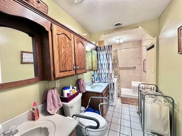 bathroom featuring toilet, tile patterned flooring, vanity, a textured ceiling, and a tile shower