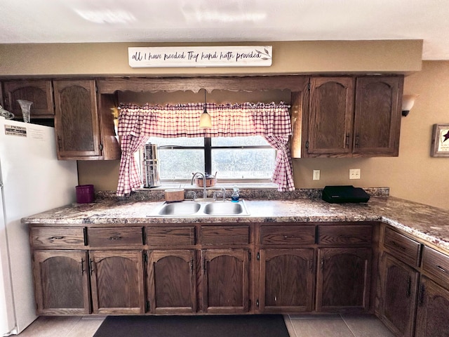 kitchen featuring white fridge, light tile patterned floors, and sink