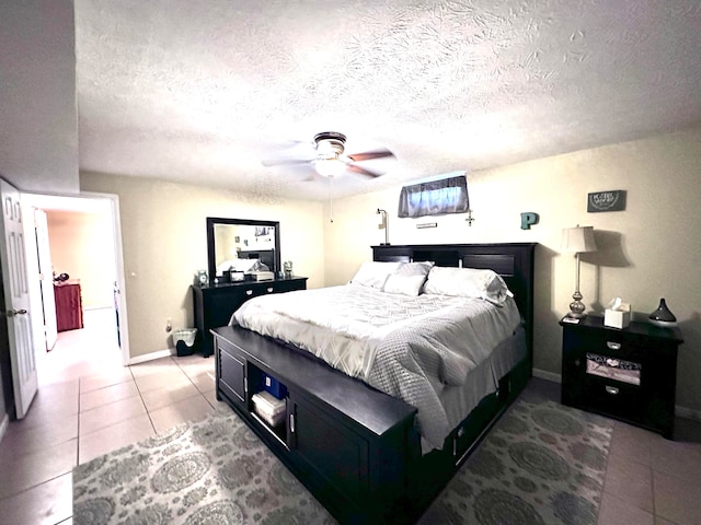 bedroom featuring a textured ceiling, ceiling fan, and light tile patterned flooring