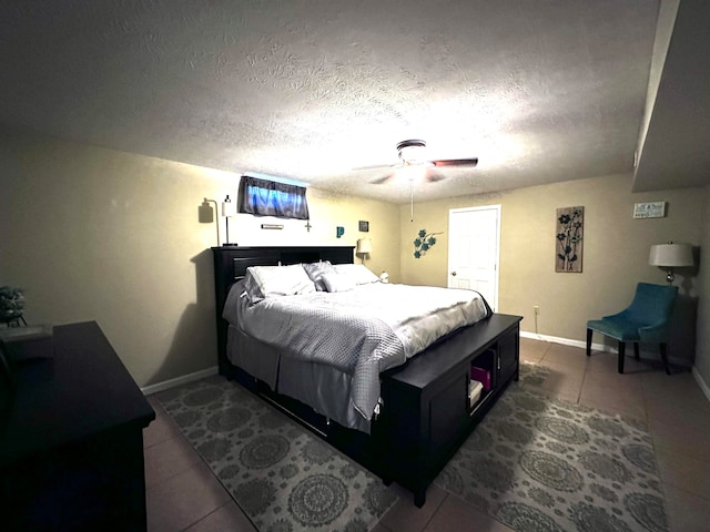 tiled bedroom with ceiling fan and a textured ceiling