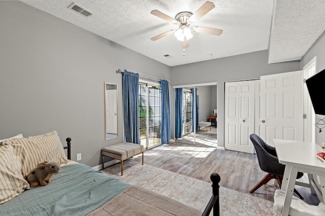 bedroom featuring ceiling fan, a textured ceiling, light hardwood / wood-style flooring, and access to exterior