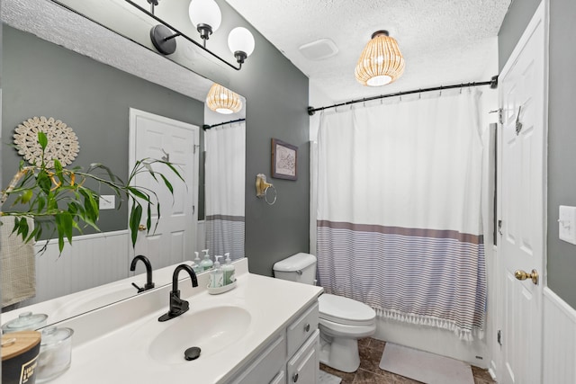 full bathroom featuring a textured ceiling, tile patterned flooring, vanity, toilet, and shower / bathtub combination with curtain