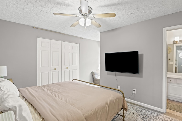 bedroom featuring ceiling fan, connected bathroom, a textured ceiling, and a closet