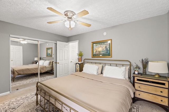 carpeted bedroom featuring ceiling fan, a closet, and a textured ceiling