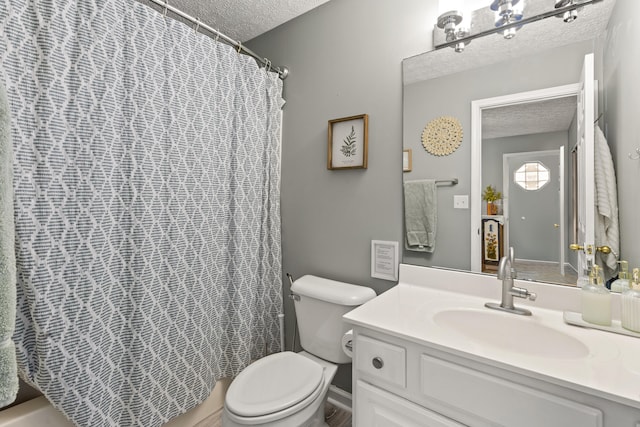 bathroom with a shower with curtain, a textured ceiling, vanity, and toilet