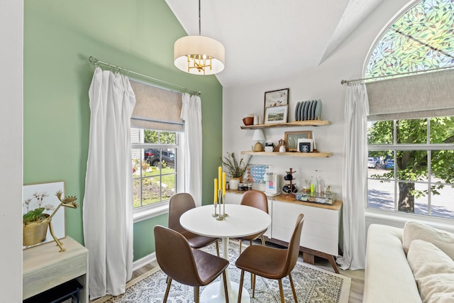 dining area featuring vaulted ceiling and light wood-type flooring