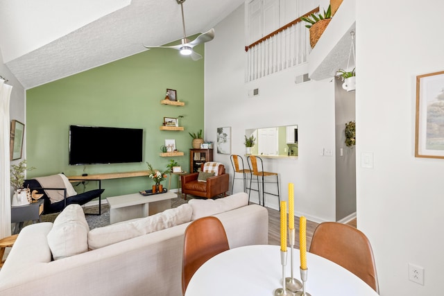 living room with ceiling fan, high vaulted ceiling, and wood-type flooring