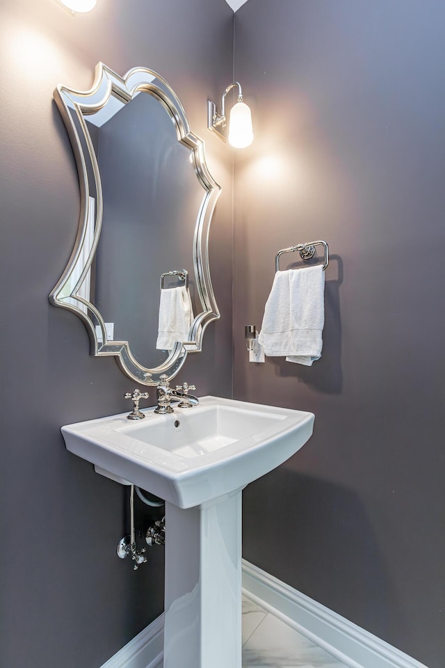 bathroom featuring marble finish floor and baseboards