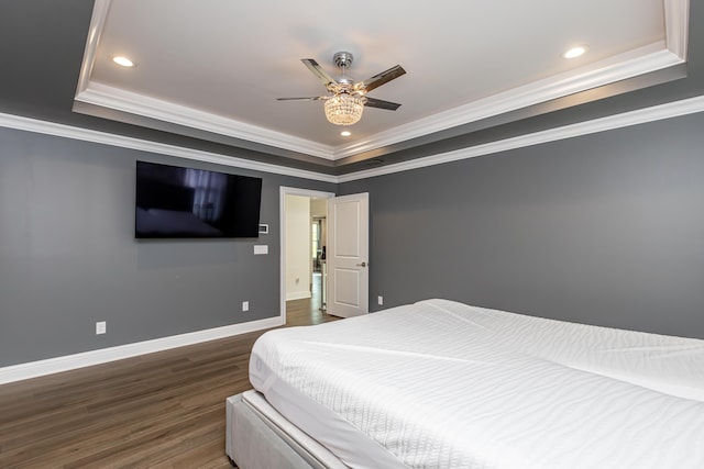 bedroom featuring crown molding, baseboards, a raised ceiling, and dark wood-style flooring