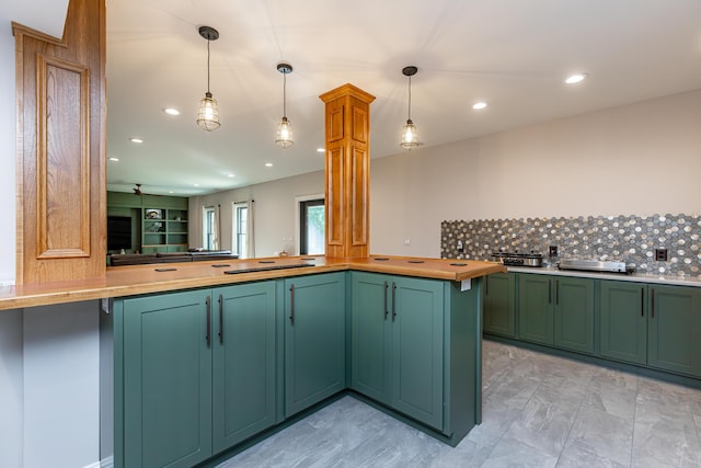 kitchen with light countertops, a peninsula, decorative backsplash, and pendant lighting