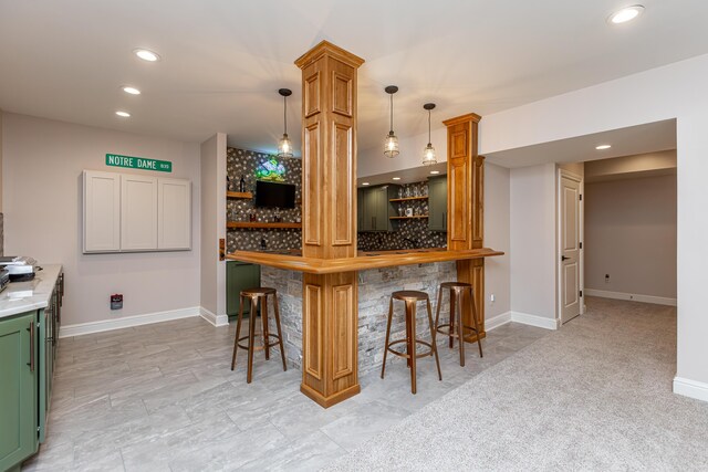 kitchen featuring decorative backsplash, butcher block counters, a breakfast bar area, hanging light fixtures, and recessed lighting