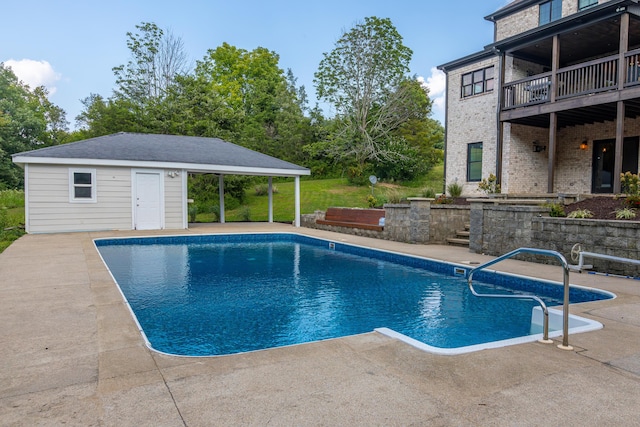 outdoor pool with a patio area, a storage structure, and an outdoor structure