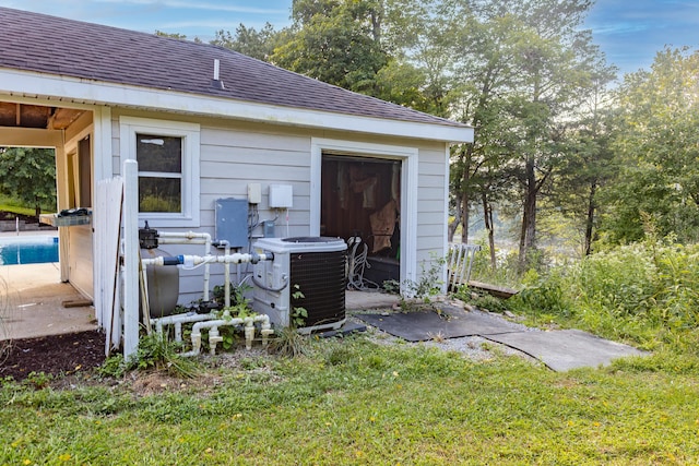 exterior space with an outdoor pool, an outdoor structure, and central AC unit