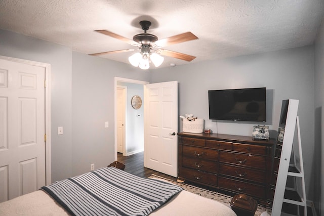 bedroom featuring a textured ceiling, ceiling fan, and dark hardwood / wood-style floors