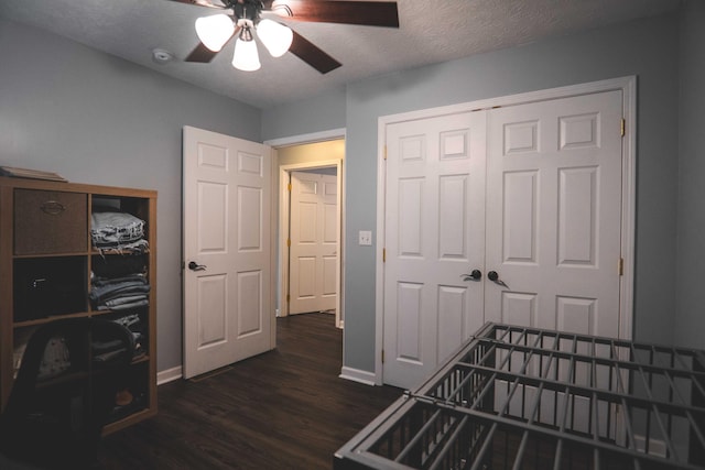 bedroom featuring ceiling fan, a closet, dark wood-type flooring, and a textured ceiling