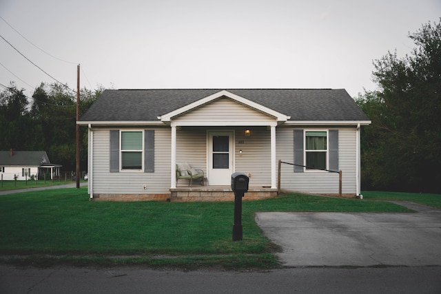 ranch-style home featuring a front lawn and covered porch