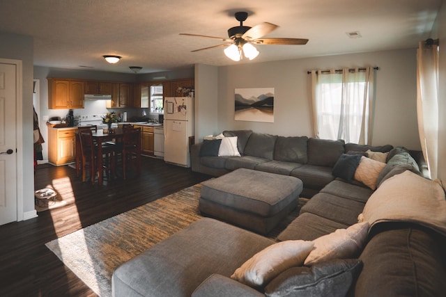 living room with ceiling fan and dark hardwood / wood-style flooring