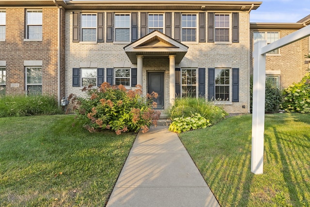 view of front of home featuring brick siding and a front lawn