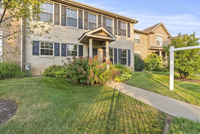 view of front of property featuring brick siding and a front yard