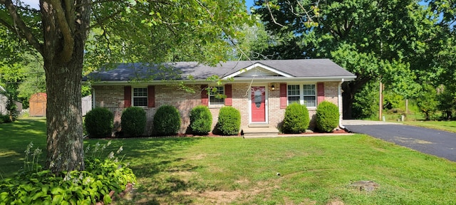 single story home with driveway, a front lawn, and brick siding