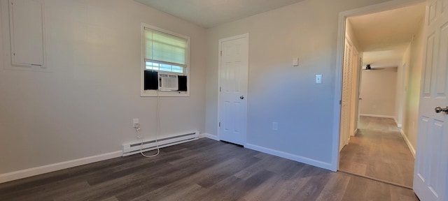 interior space featuring a baseboard heating unit, cooling unit, dark wood-style flooring, and baseboards