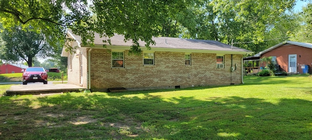 view of side of property with crawl space, a lawn, and brick siding