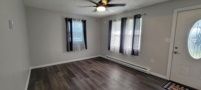 entrance foyer with a textured ceiling, ceiling fan, dark wood-type flooring, and a baseboard heating unit