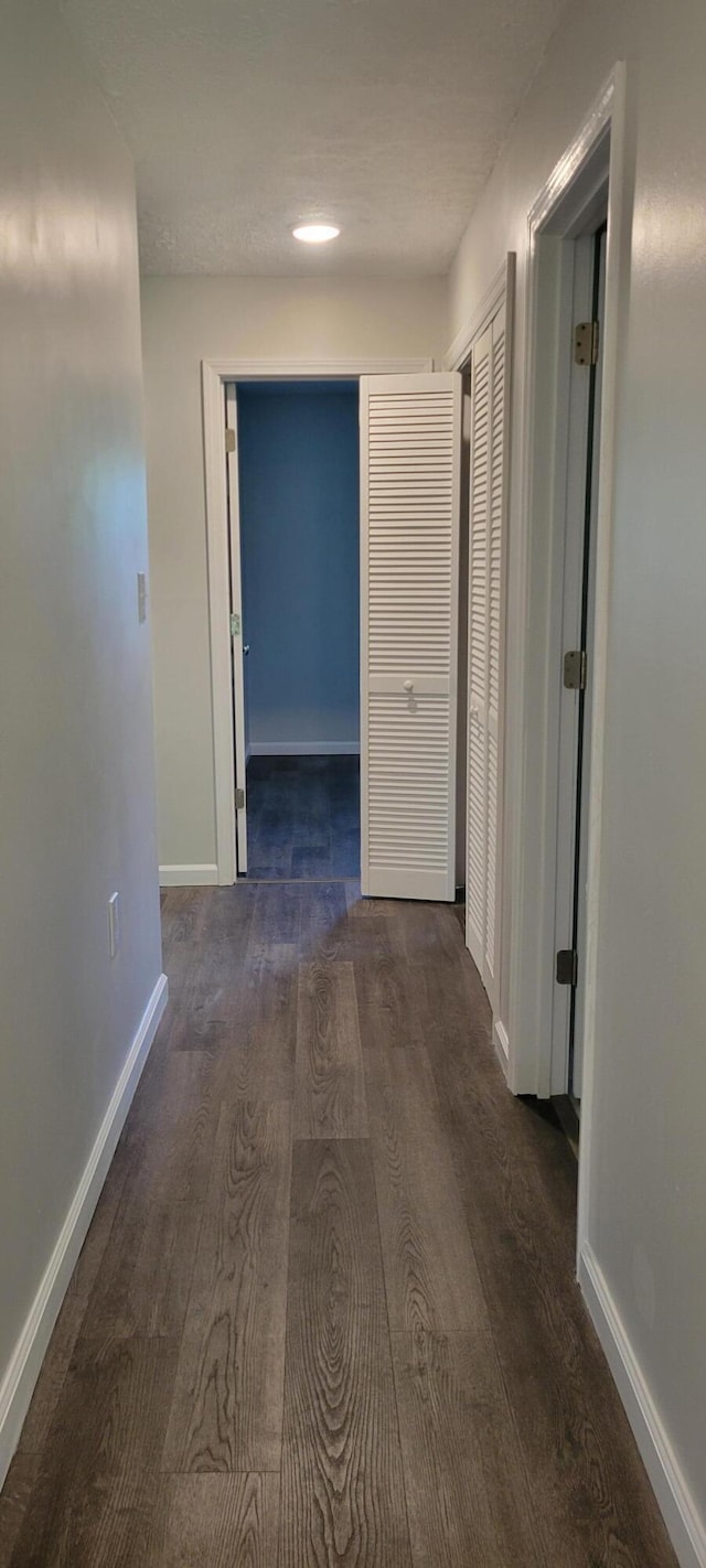 hall featuring wood finished floors and baseboards