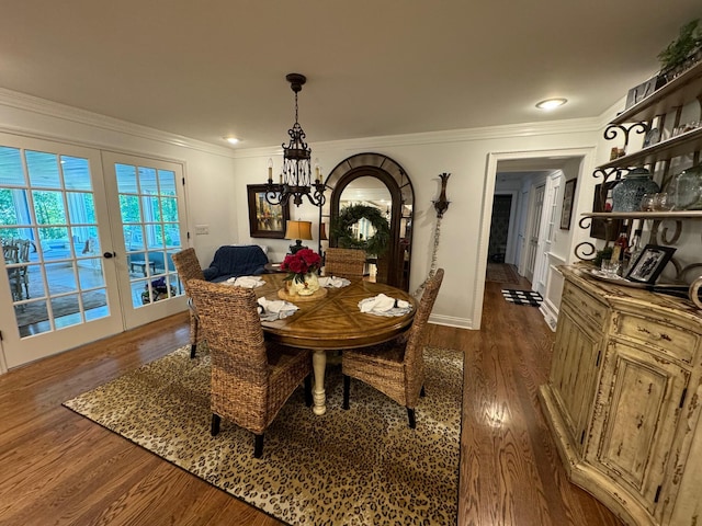 dining area with ornamental molding, hardwood / wood-style floors, an inviting chandelier, and french doors