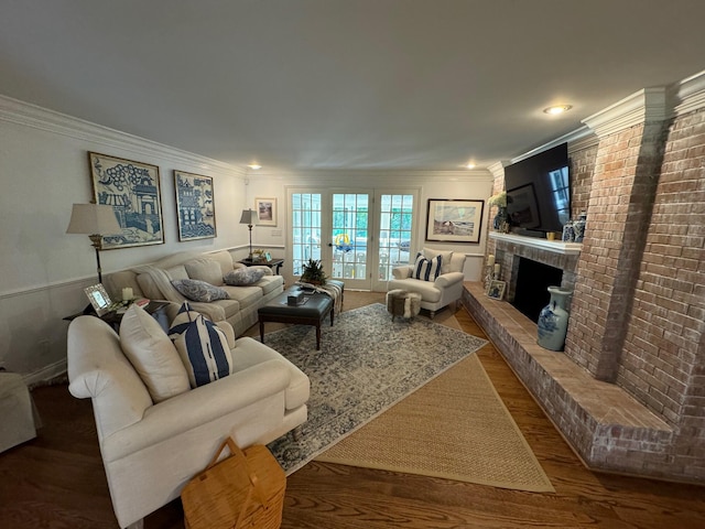 living room featuring a fireplace, ornamental molding, and wood-type flooring