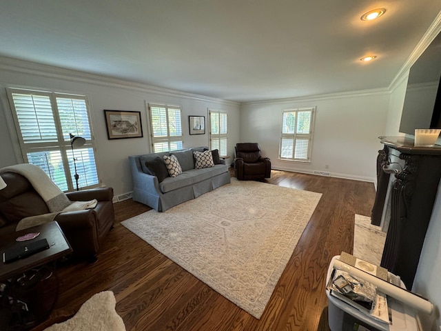 living room featuring dark hardwood / wood-style flooring, a wealth of natural light, and ornamental molding