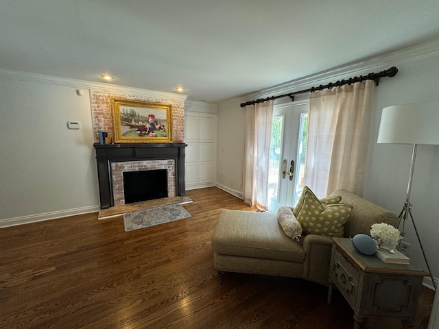 living room with hardwood / wood-style flooring, ornamental molding, french doors, and a brick fireplace